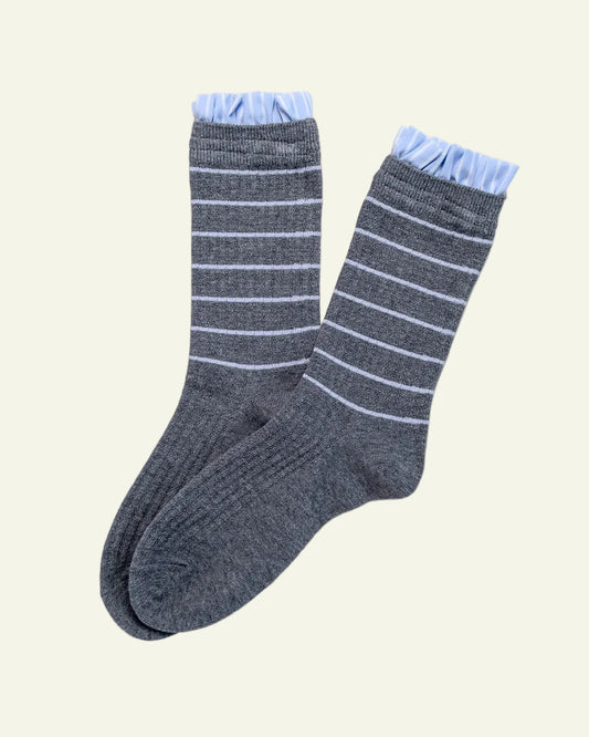 Pair of gray socks with white stripes on a light gray background
