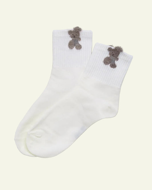 White socks with teddy bear designs on a beige background