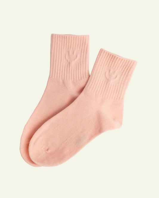 Pair of pink socks on a light gray background