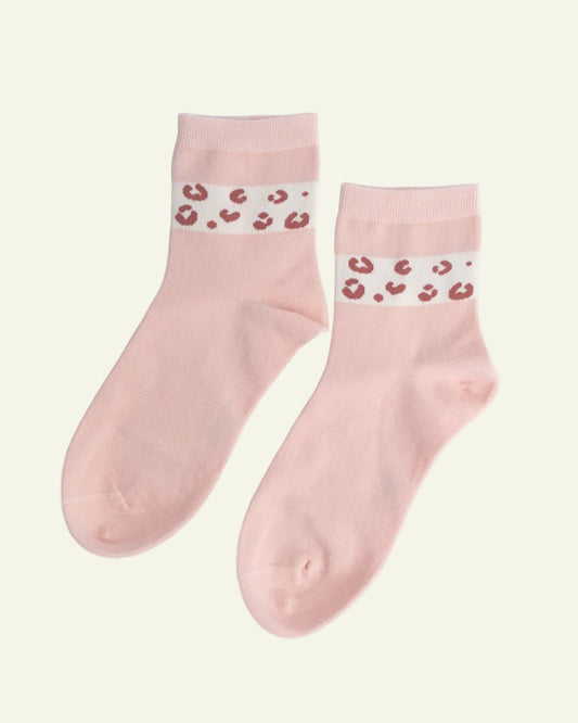 Pair of pink socks with leopard print bands on a light gray background