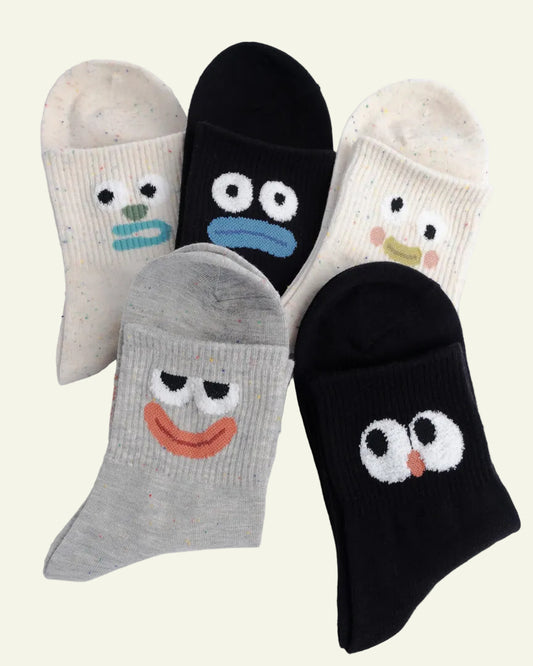 Set of five socks with cartoon face designs on a light gray background