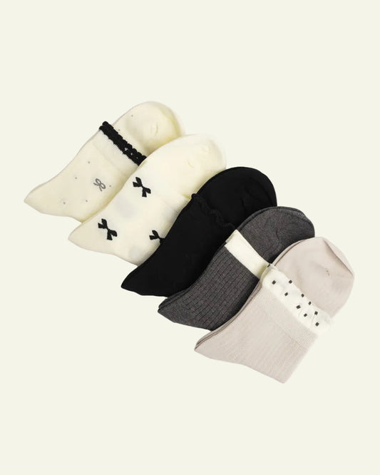 Set of five pairs of socks in various colors on a light gray background