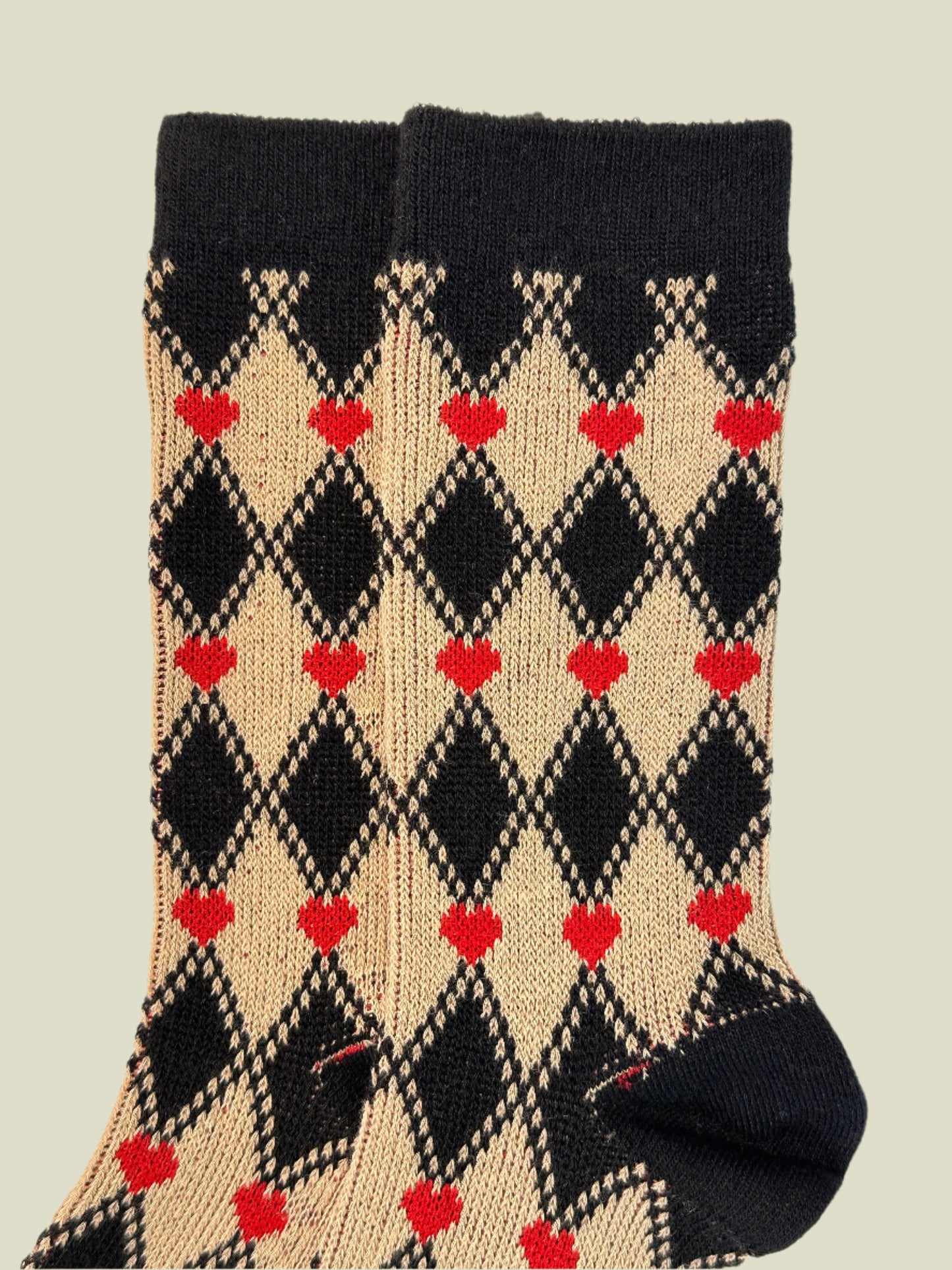 Textile with black, beige, and red diamond pattern on a white background