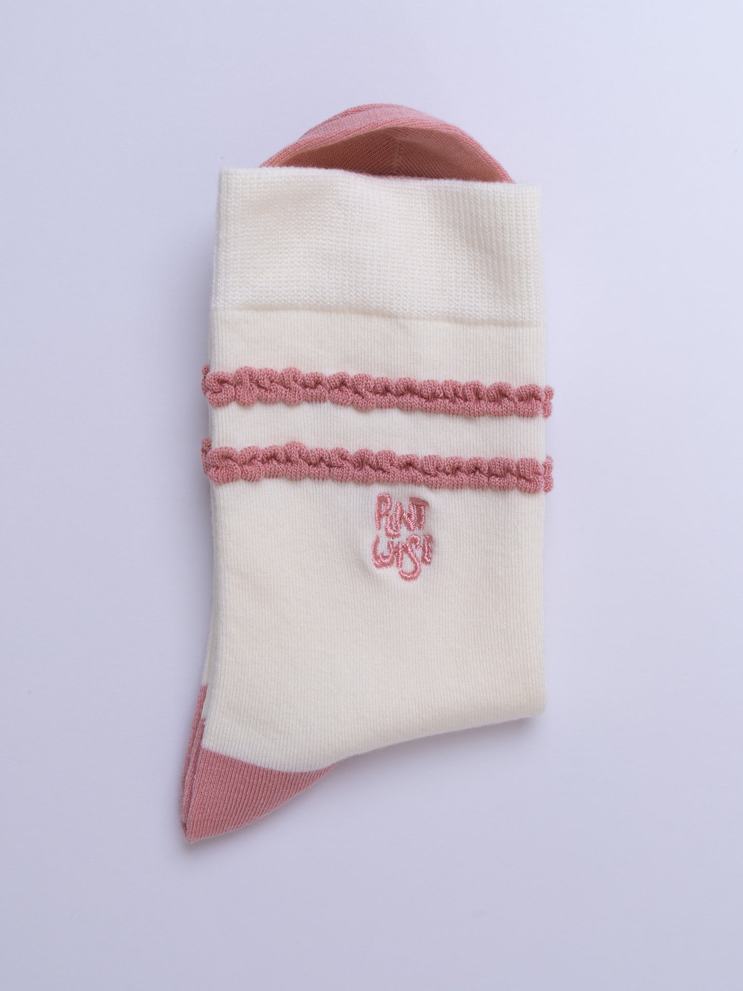 White sock with pink trim and logo on a light purple background