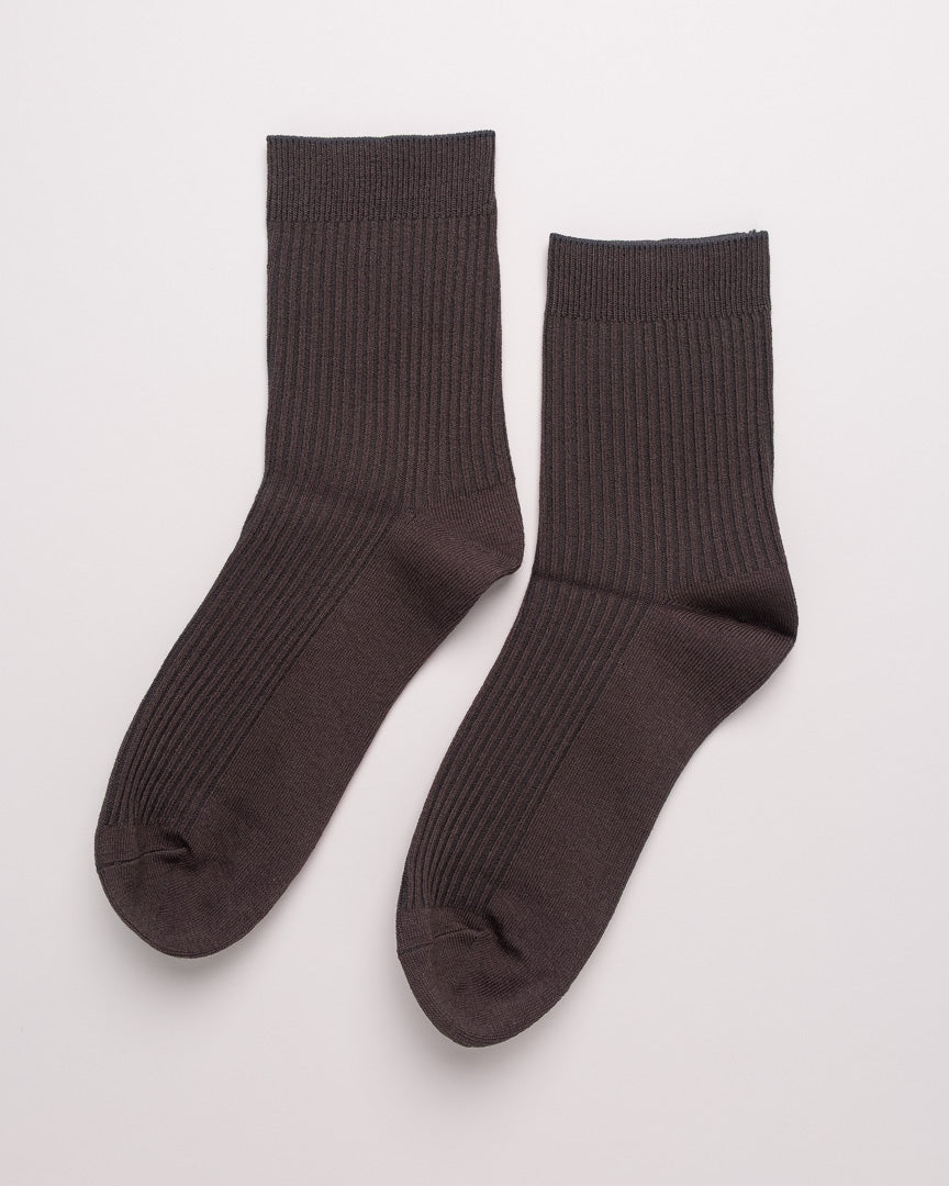 Pair of dark brown socks on a light gray background