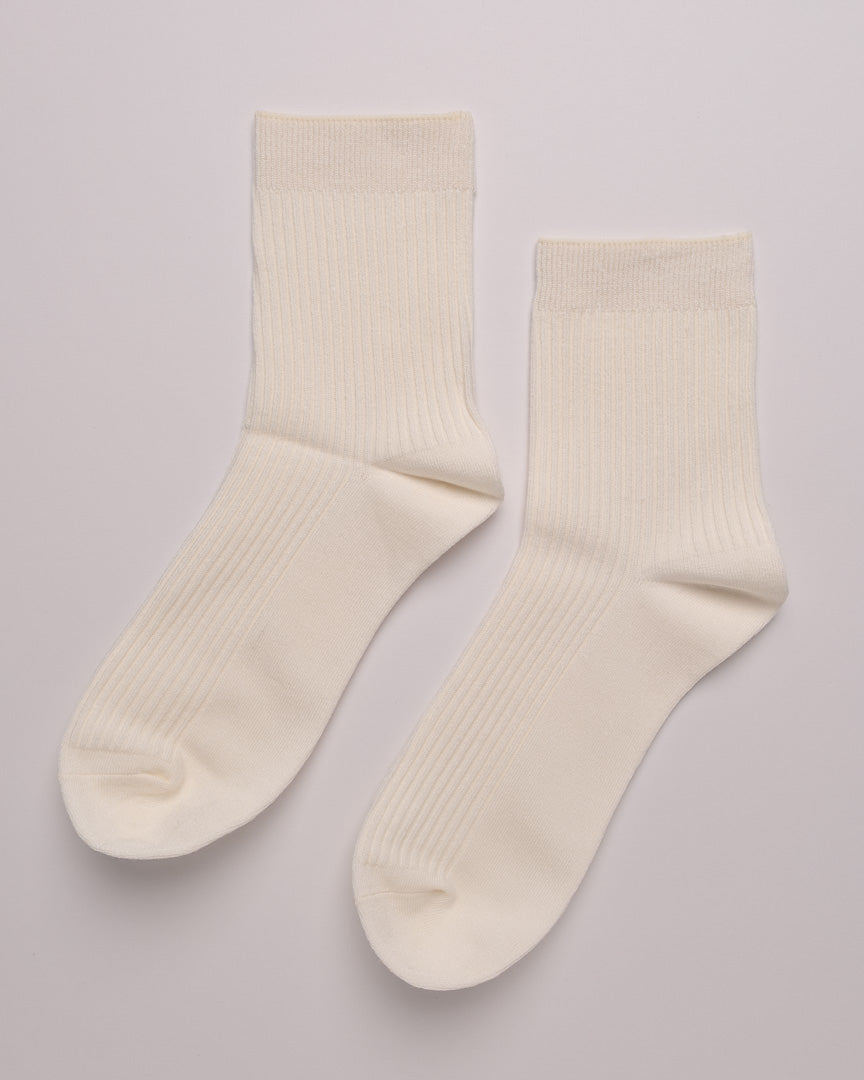 Pair of cream-colored socks on a light gray background