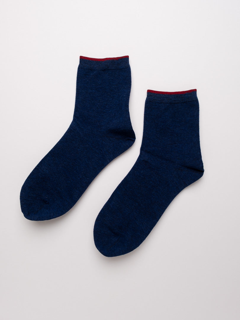 Pair of navy blue socks on a light gray background