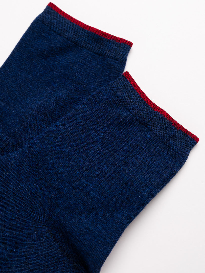 Close-up of blue socks with red trim on a white background