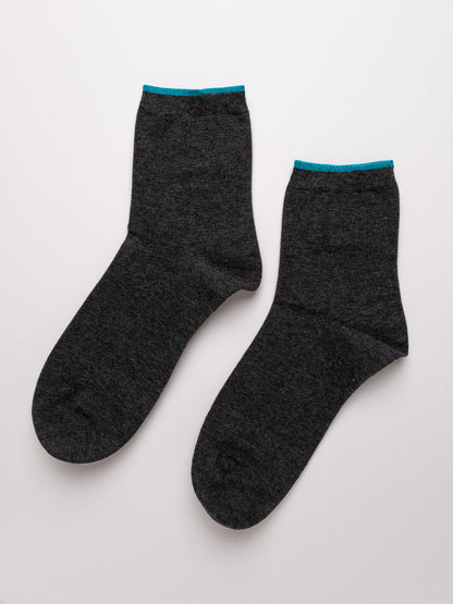 Pair of dark gray socks with light blue trim on a white background