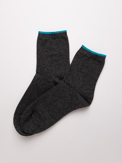 Pair of dark gray socks with teal accents on a light gray background