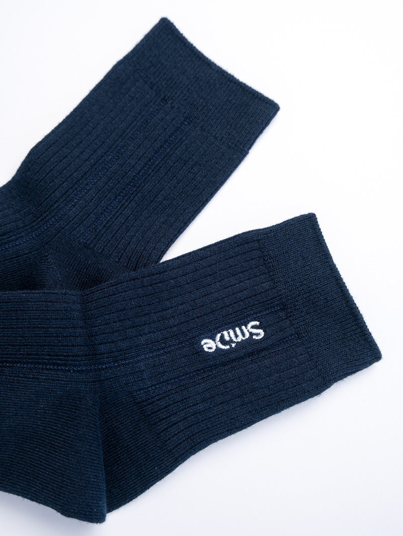 Pair of navy blue socks with a logo on a white background