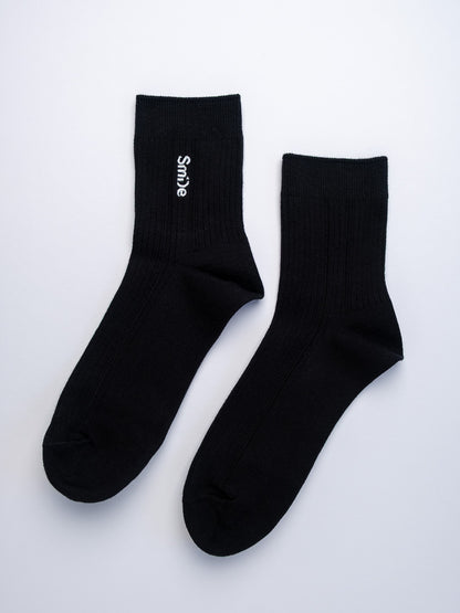 Black socks with white text on a light gray background