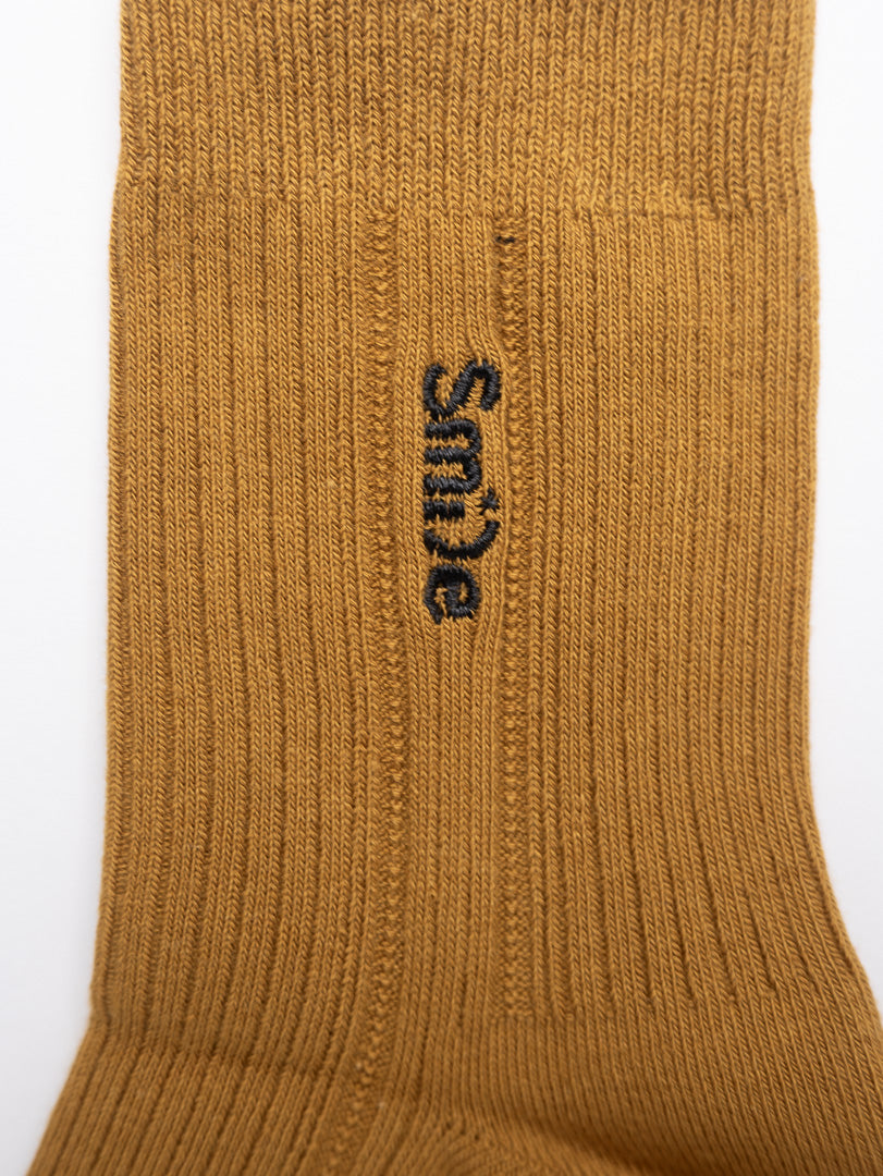 Brown sock with 'Smile' logo on a white background