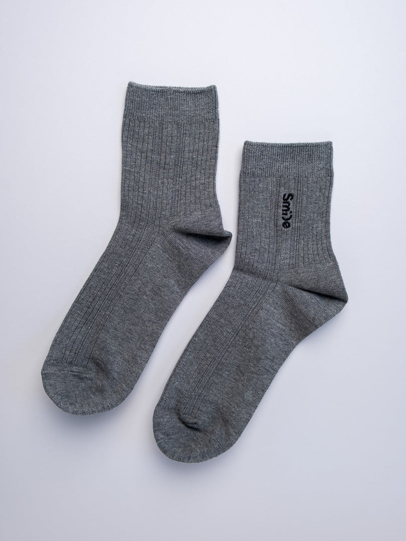 Pair of gray socks with a brand logo on a white background