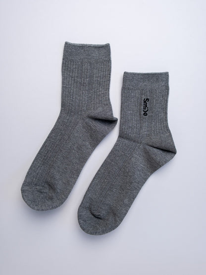 Pair of gray socks with a brand logo on a white background