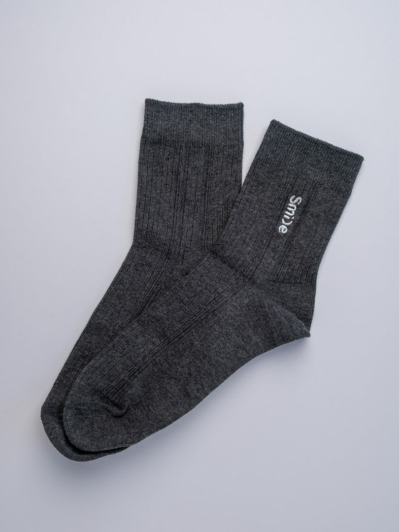 Pair of gray socks with 'Simple' branding on a light gray background