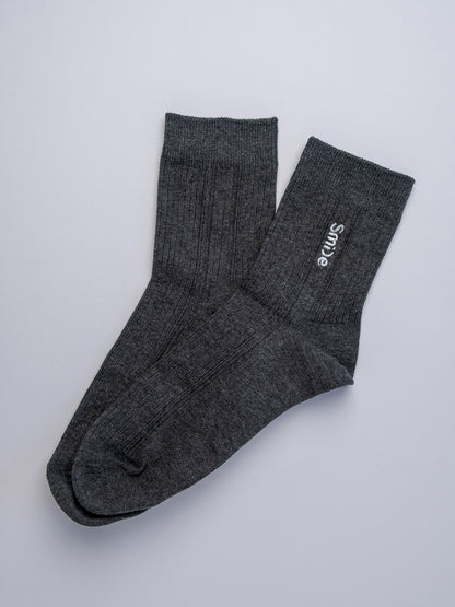 Pair of gray socks with 'Simple' branding on a light gray background