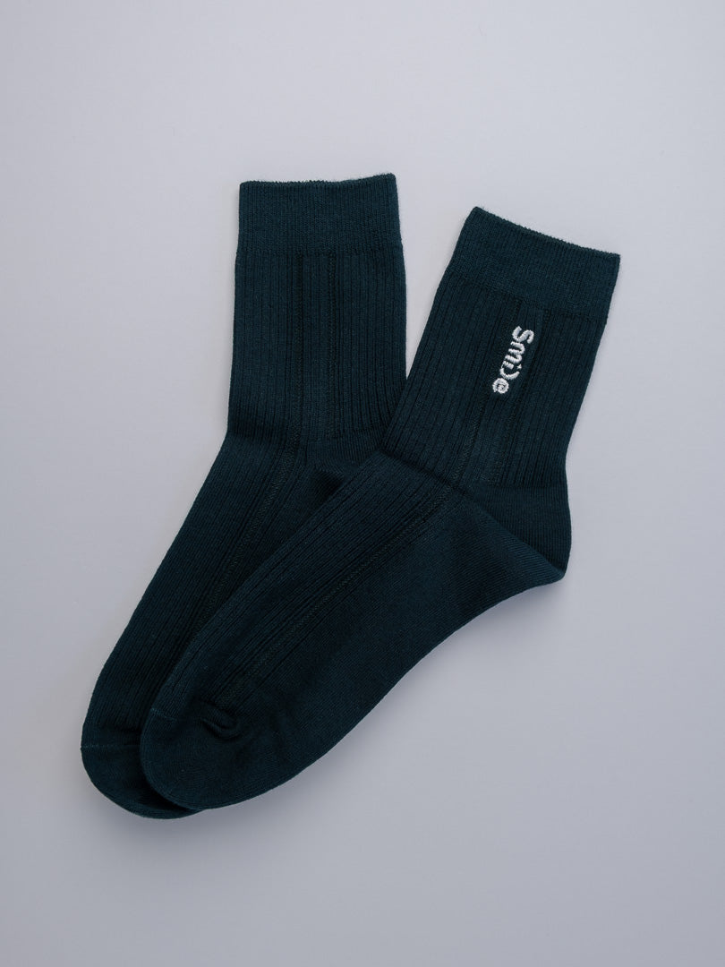 Pair of black socks with a brand logo on a light gray background
