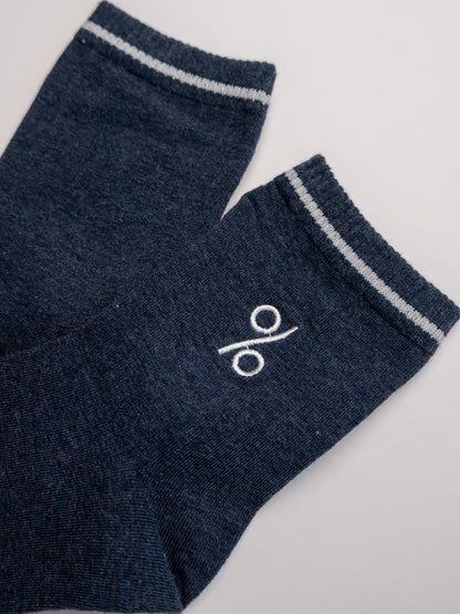 Pair of dark blue socks with a white logo on a light gray background