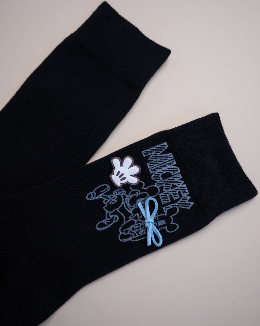 Black socks with embroidered design on a light gray background