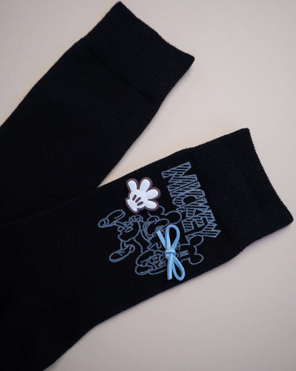 Black socks with embroidered design on a light gray background