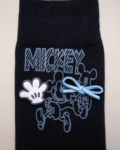 Black sock with Mickey Mouse design on a beige background