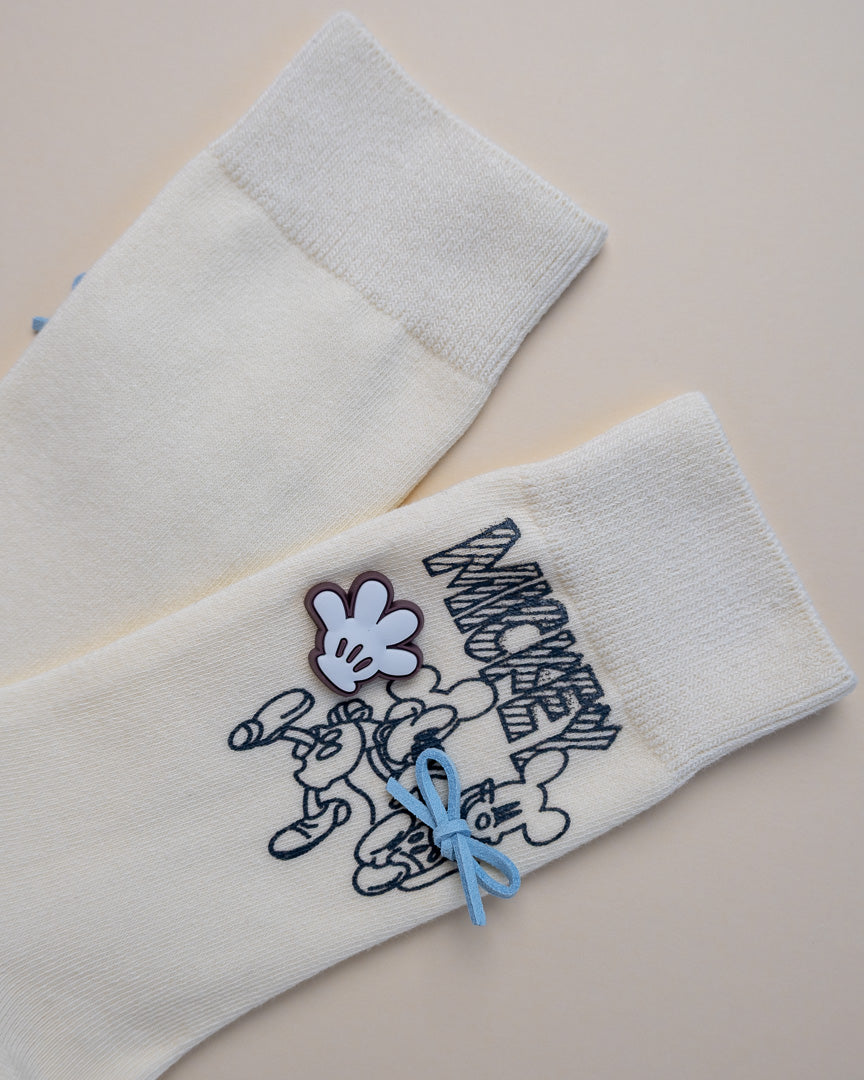 White socks with cartoon character design on a beige background