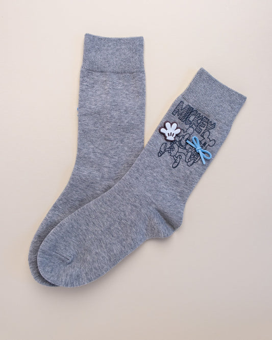Gray socks with a cartoon character design on a beige background