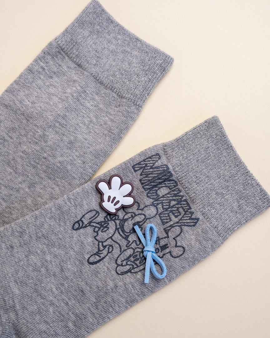 Gray socks with a cartoon character design on a beige background