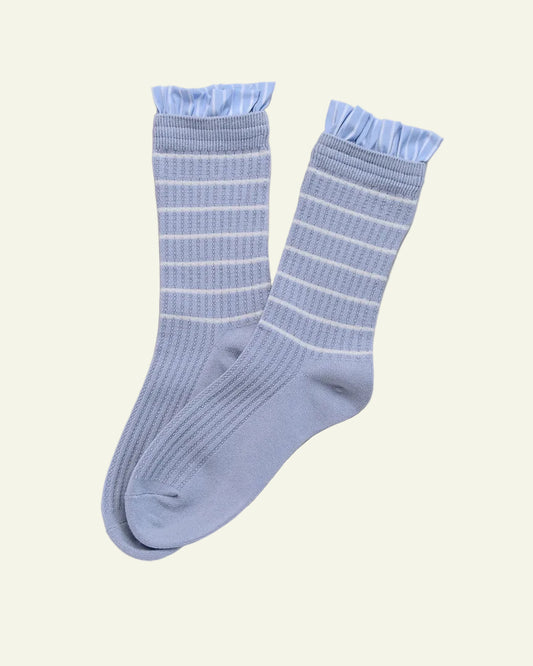 Pair of light blue socks with white stripes on a beige background