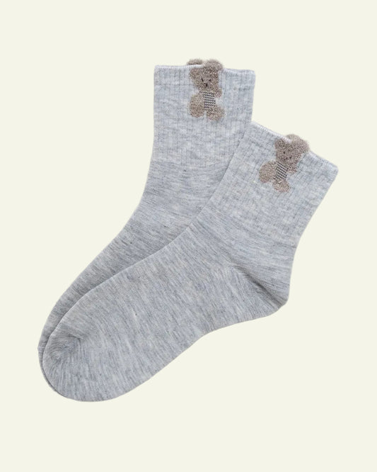 Gray socks with teddy bear designs on a beige background