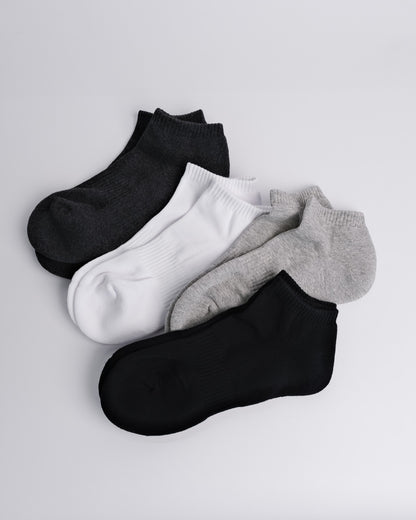 Set of four pairs of black, white, and gray ankle socks on a light gray background