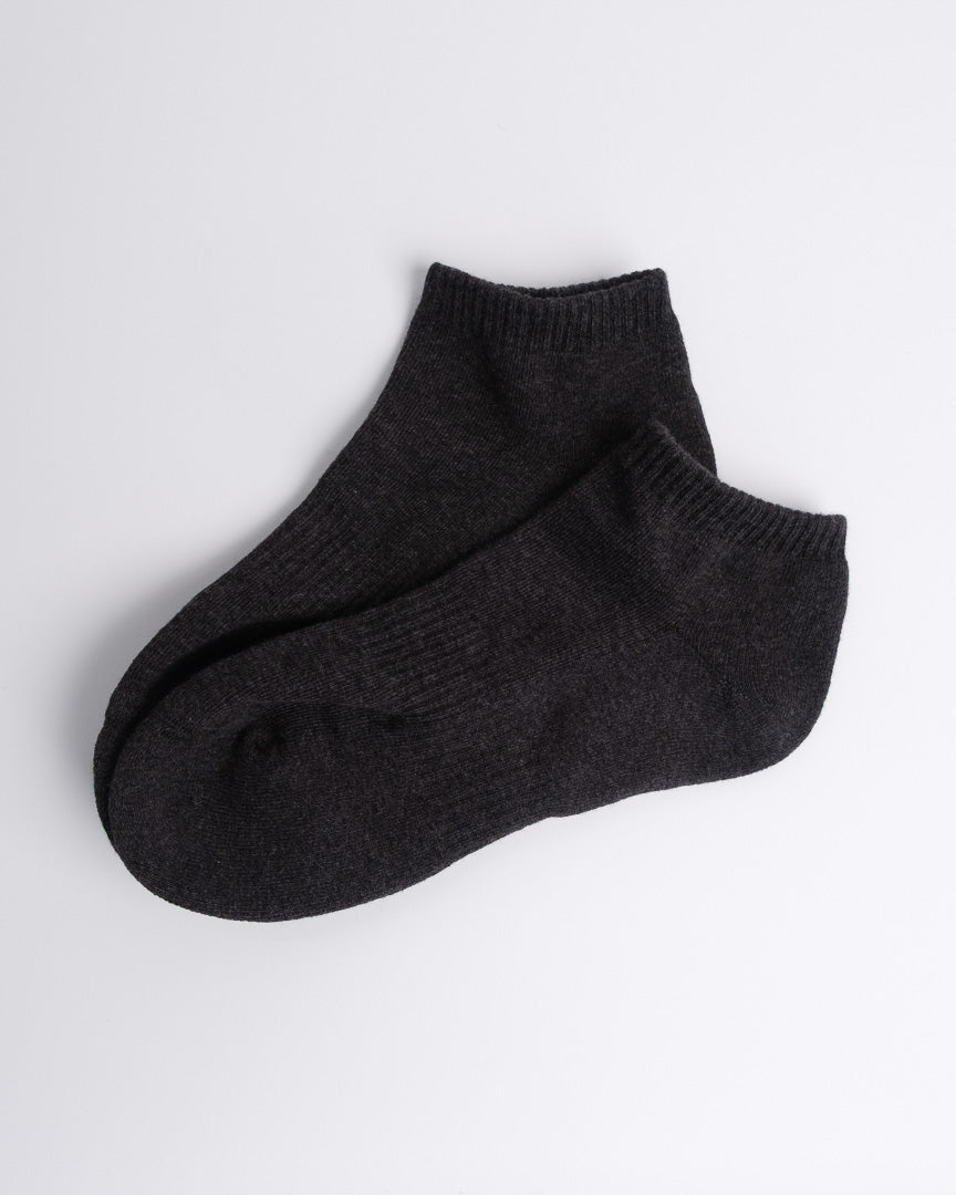 soft dark grey cotton ankle socks laid flat on a white backdrop