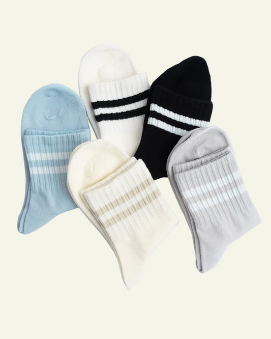 Set of five pairs of socks in various colors on a light gray background