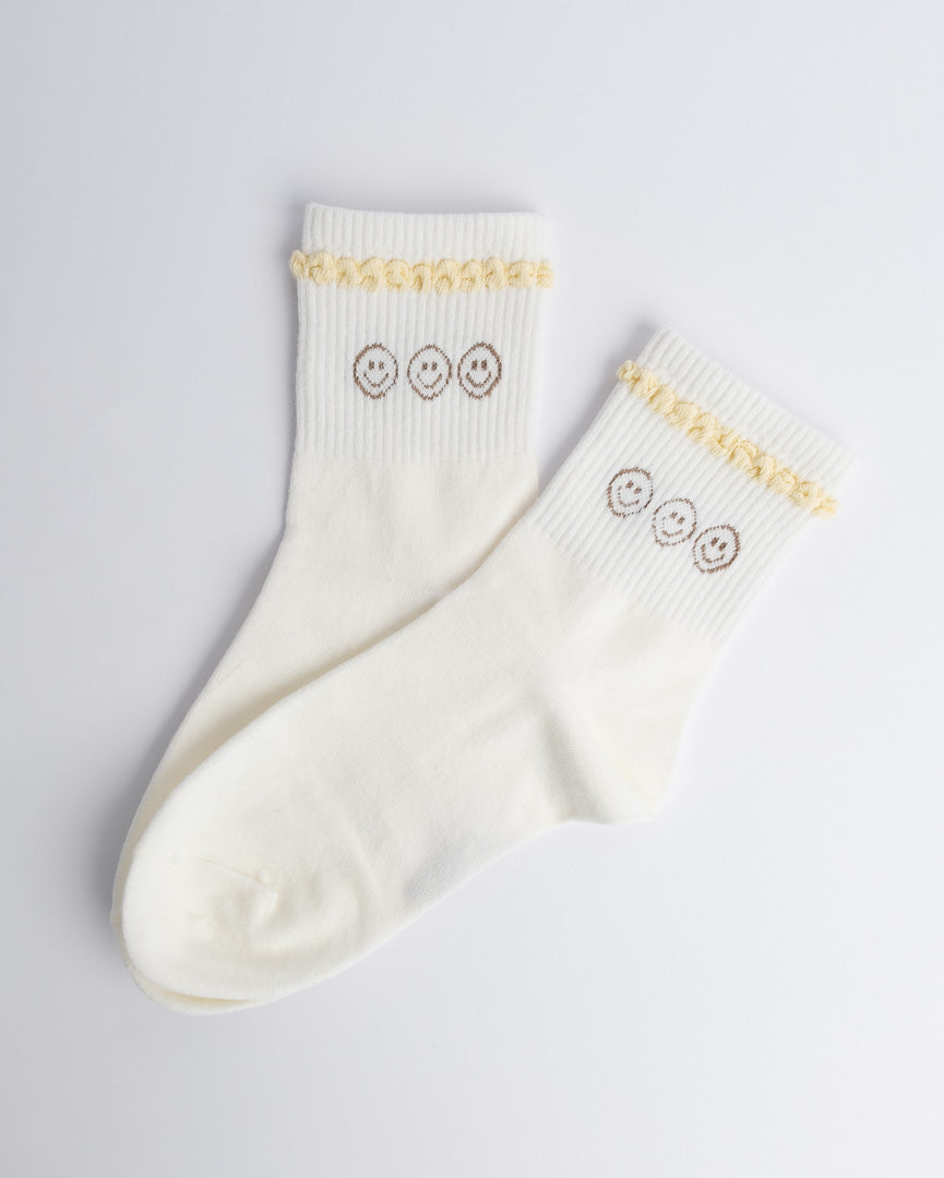 Cream women’s cotton quarter socks with smiley pattern and ruffle cuff