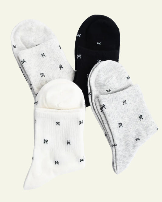 Set of white and black socks with small black designs on a light gray background