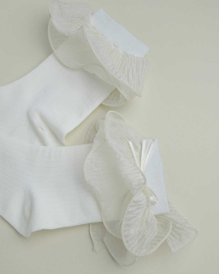 Detail of cream white sheer ruffle socks showing lightweight translucent ruffle edge