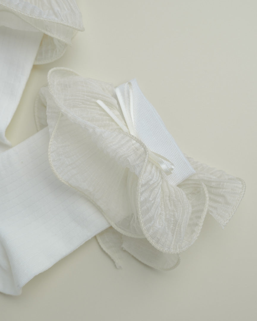 Close-up of sheer ruffle trim on cream white women’s cotton crew socks