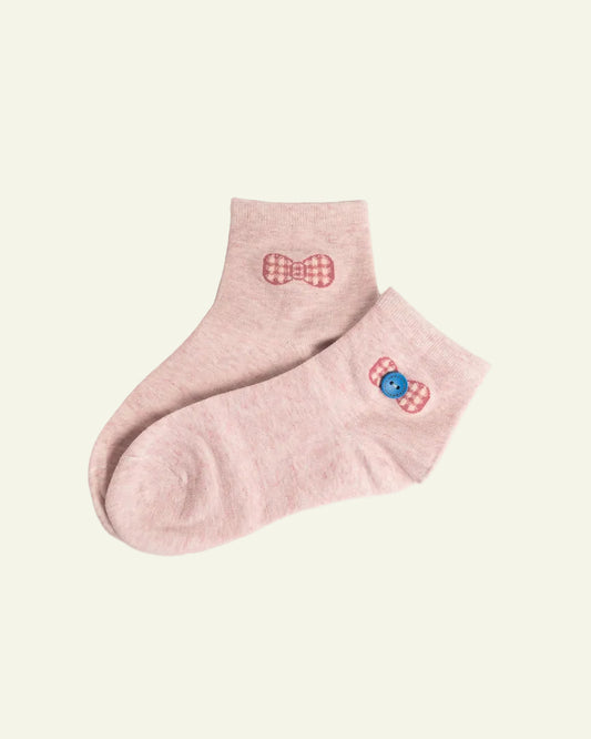 Pink ankle socks with decorative elements on a light gray background