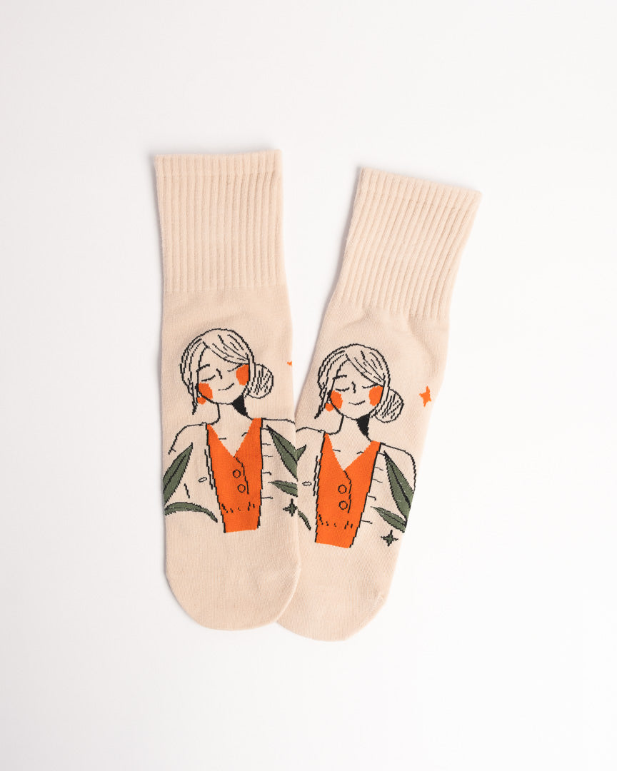 Beige socks with a graphic of a woman in a dress on a white background