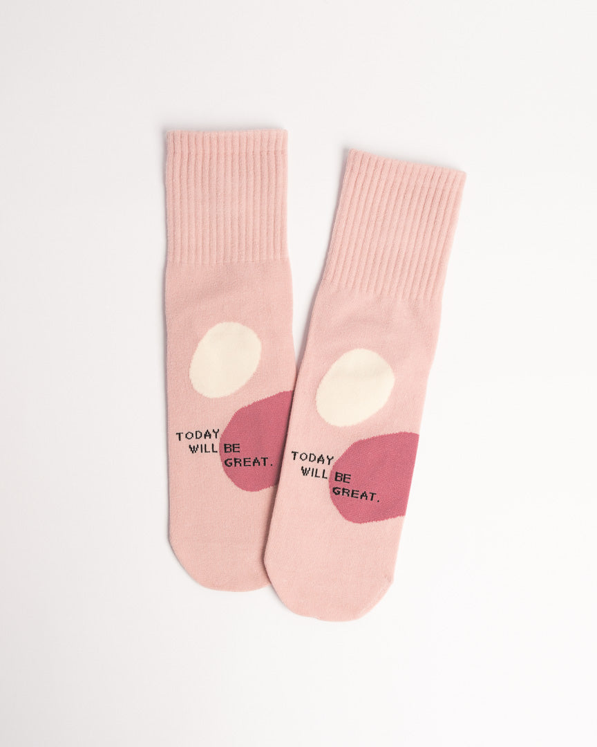Pink socks with heart designs and text on a white background