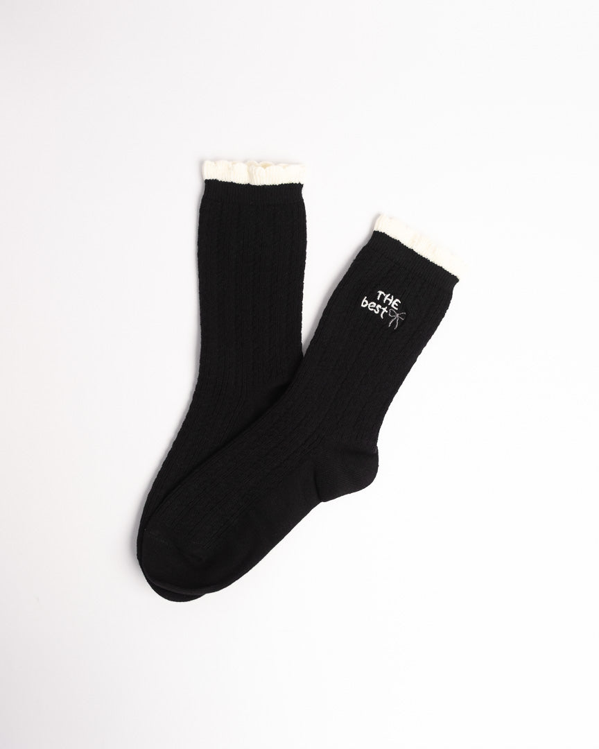 Black women's ribbed cotton crew socks with contrast ruffle cuff and embroidered bow detail
