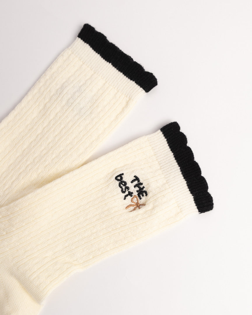 Black and cream women's cotton crew socks with contrast ruffle cuff and ribbed texture
