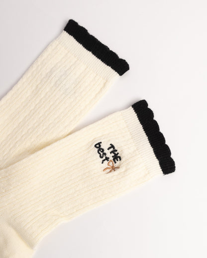Black and cream women's cotton crew socks with contrast ruffle cuff and ribbed texture