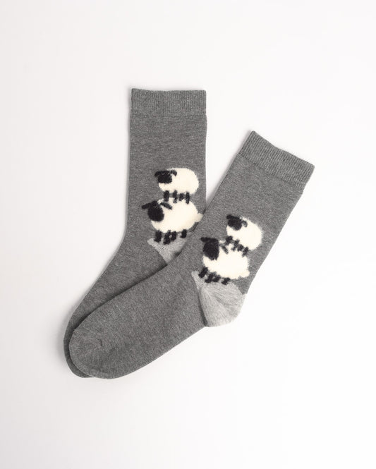 A pair of heather gray crew socks with a black and white sheep pattern on the sides, displayed on a clean white background.