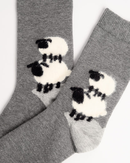 A pair of heather gray knit socks featuring a large white and black sheep motif on each sock, photographed against a plain white background.
