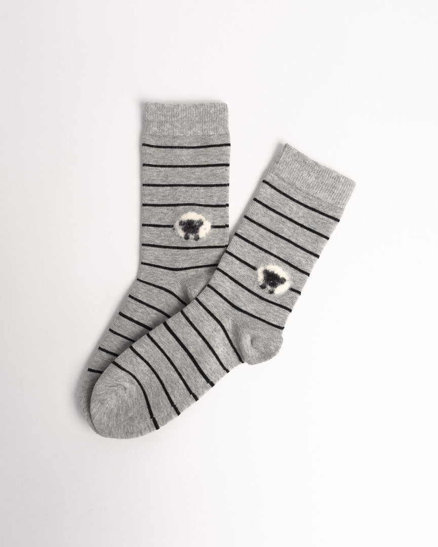 A pair of gray crew socks with thin black horizontal stripes and a small white-and-black sheep motif near the cuff, displayed on a clean white background.