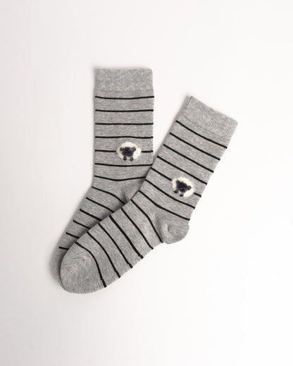 A pair of gray crew socks with thin black horizontal stripes and a small white-and-black sheep motif near the cuff, displayed on a clean white background.