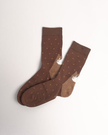 A pair of brown crew socks with small tan polka dots and a brown-and-white hedgehog design on the side, displayed on a clean off-white background.