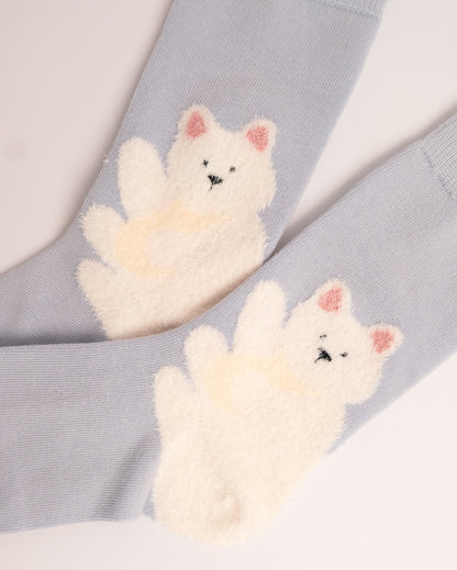 A pair of light blue ribbed socks featuring large, fluffy cream-colored bear appliques on the front, with pink inner ears and small black stitched facial details.